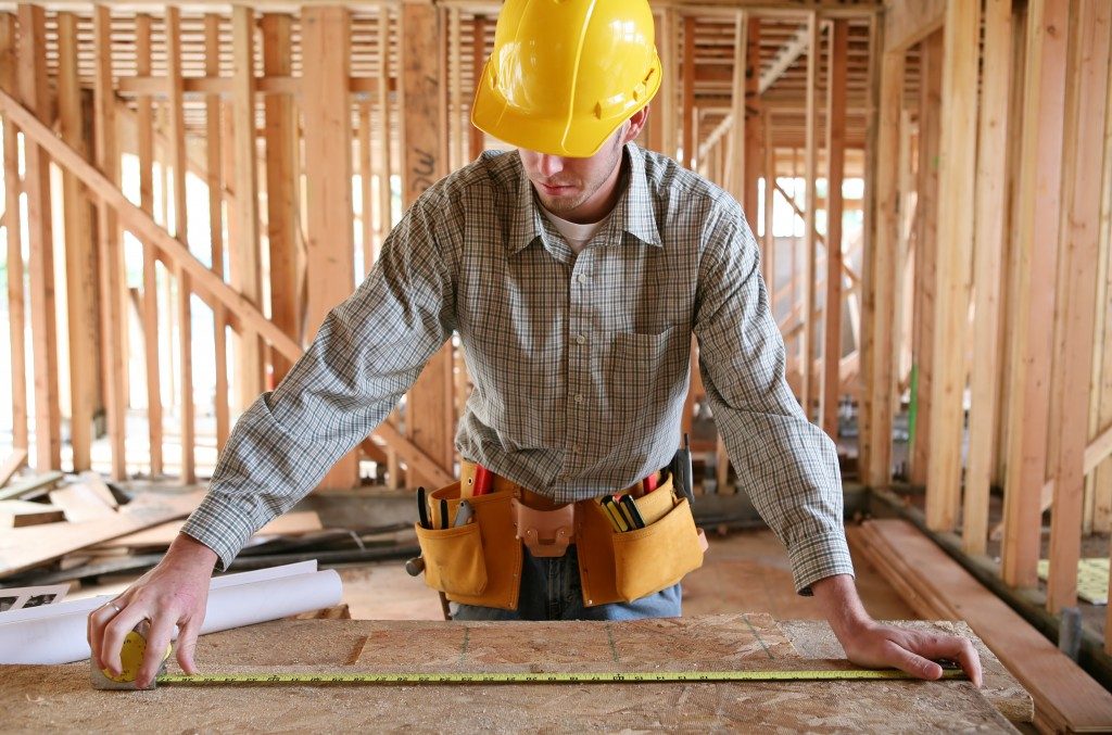 contractor measuring a wood