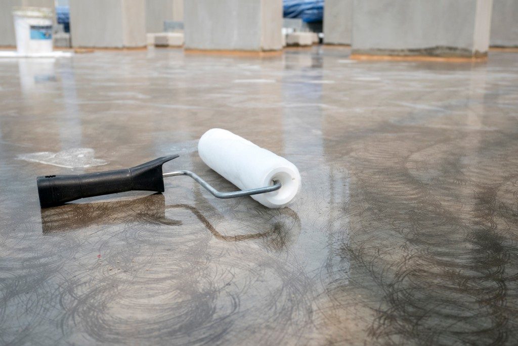 Roller brush placed on concrete floor