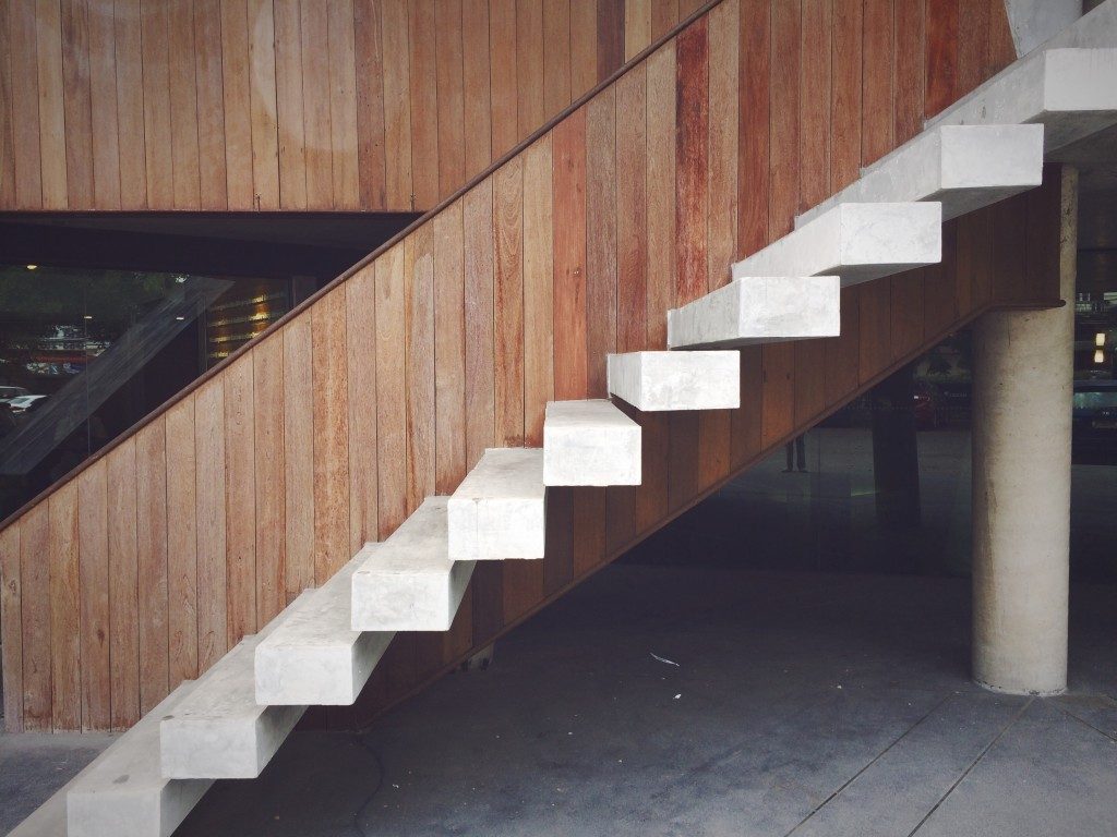 White floating staircase design with the wooden background.
