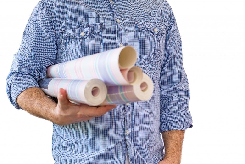 a man holding some wallpaper